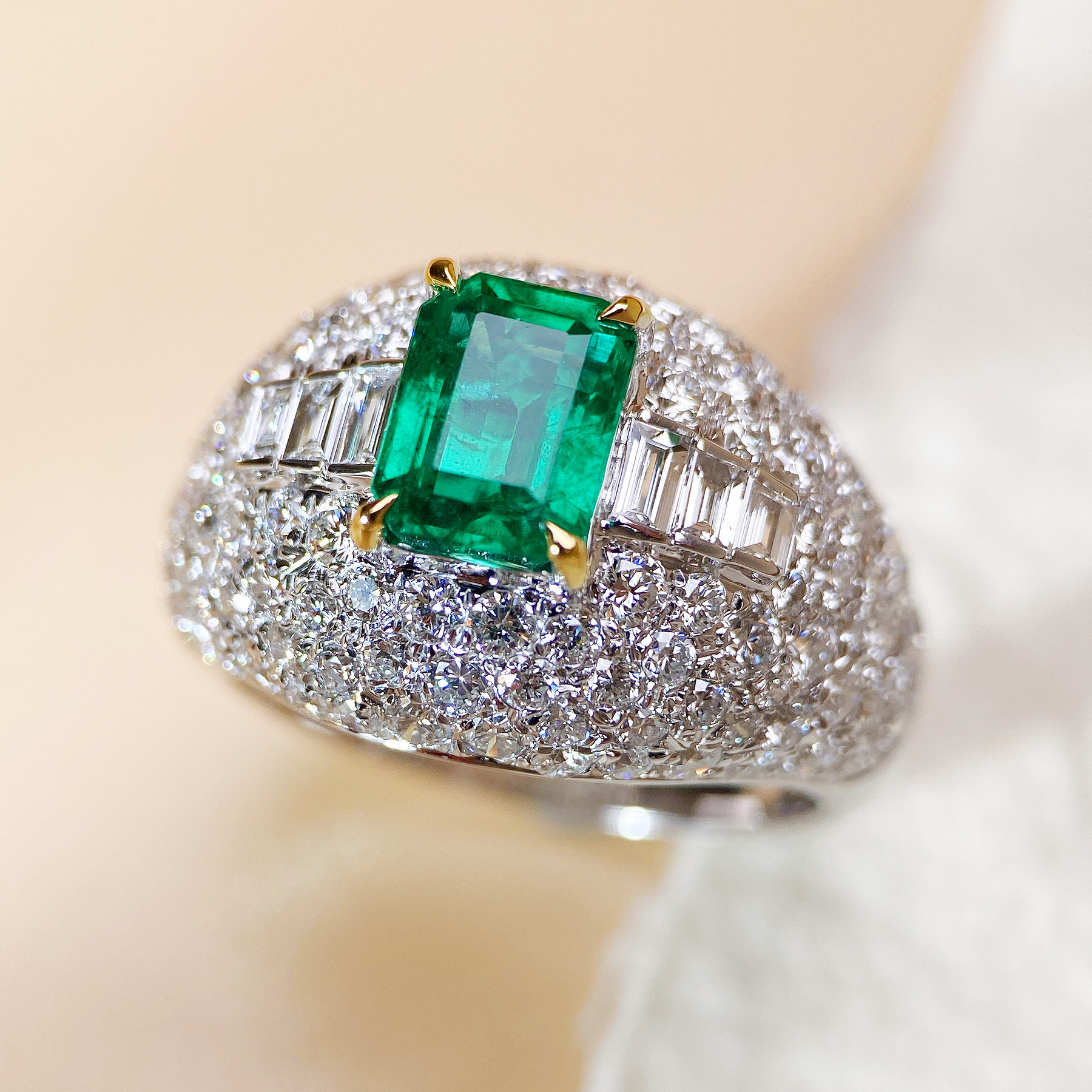Emerald ring photographed on a pale background