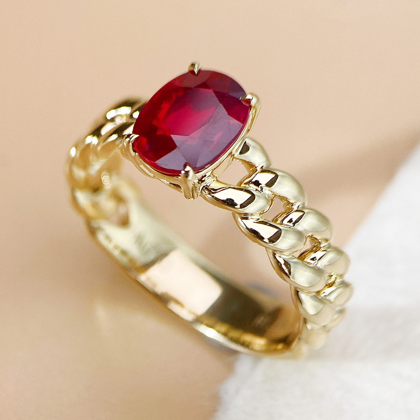 Red gemstone ring photographed on a pale background